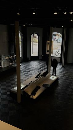 a man standing in the middle of a room next to a table with an object on it