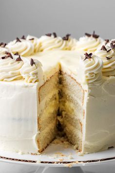 a cake with white frosting and chocolate sprinkles is cut in half