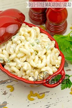 a red bowl filled with macaroni salad on top of a table