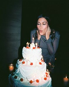 a woman blowing out candles on a cake