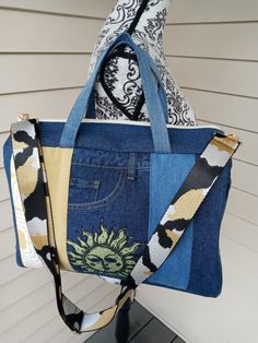 a handbag made out of jeans and fabric with an image of a sun on it