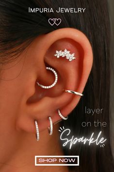 a woman wearing three different types of ear piercings