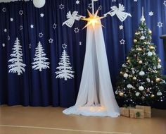 a christmas tree and decorations in front of a curtain