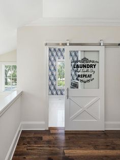 an empty room with a white door and blue patterned wall paper on the window sill