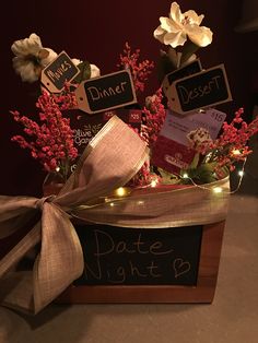 a wooden box filled with chocolates and flowers next to a chalkboard sign that says date night