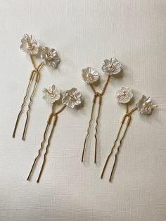 Hair pins with beautiful handmade flowers and beads.  Sold as pack of 4. ITEM SPECIFICATIONS ✨ Package: Pack of 4 pin. ✨ Color: Gold ✨ Material: Clay, white beads and crystal. 💛 Due to differences in light color and display in the photo, the actual item may vary slightly. Each of our products is measured by hand. There may be some differences in measurements.  PROCESSING AND SHIPPING ✨ Your order will be 1-5 business days. ✨ Please check out our shop In case of questions about the product or if Floral Hair Pins Wedding, Flower Wedding Hair, Wedding Hair Pin, Hair Pins Wedding, Wedding Hair Jewelry, Floral Hair Pins, Crystal Hair Pins, Wedding Hair Flowers, Wedding Hair Pins