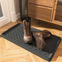 two pairs of boots sitting on top of a mat