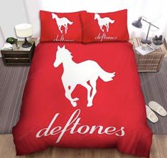 a red bed with white horses on it and the words deftones printed on it