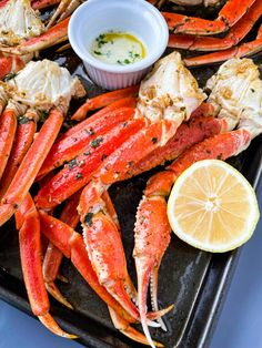 lobsters on a tray with lemon wedges and dipping sauce