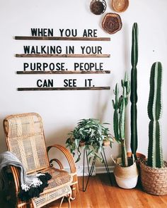 a living room with some plants on the wall and a quote above it that says, when you are walking in your purpose people can see it