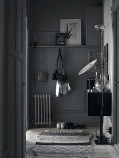 a room with a rug, lamp and radiator in black and white photo