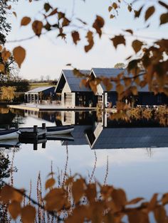 a house sitting on top of a lake next to a boat dock in front of it