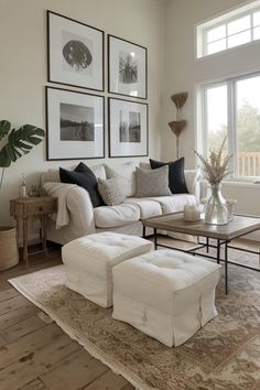 a living room filled with white furniture and pictures on the wall above it's coffee table