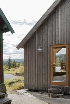 a wooden building with a large mirror on the door and window sill in front of it