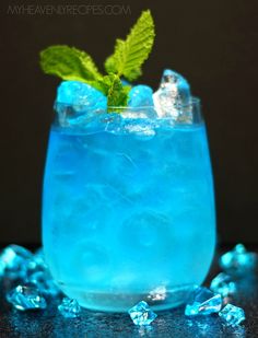 a blue cocktail with mint garnish and ice cubes