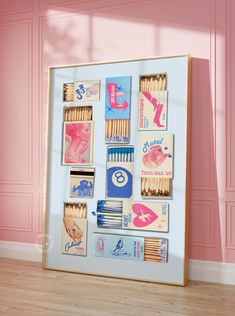 an art work with matches, matchesticks and other items on it in a pink room