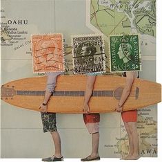 two people holding a wooden surfboard in front of a map with stamps on it