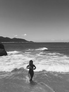 a woman is wading in the water at the beach