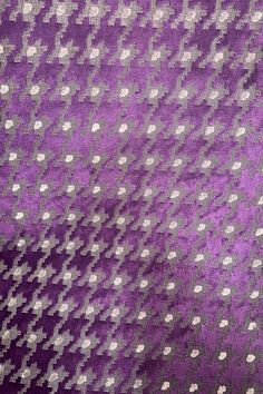 an abstract purple and silver background with white polka dots on the fabric, closeup