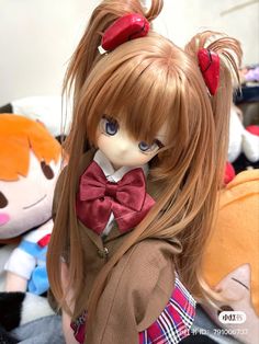 a close up of a doll with long hair and red bows on it's head