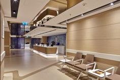 an empty waiting room with two chairs and a counter in the middle is lit by recessed lights