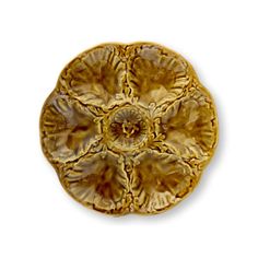 a golden flower shaped dish sitting on top of a white surface