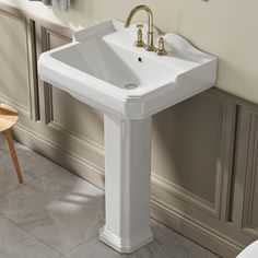 a white pedestal sink sitting next to a bath tub