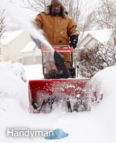 a man is using a snow blower to clear the snow from his yard in winter