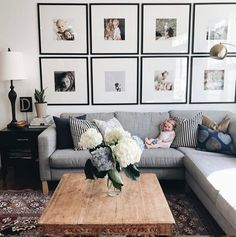 a living room with pictures on the wall and a couch in front of a coffee table