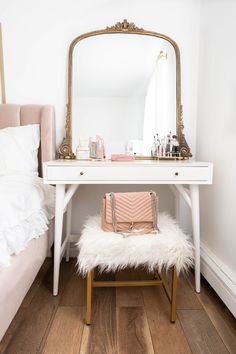 a white desk with a mirror and a bench in front of it on top of a hard wood floor