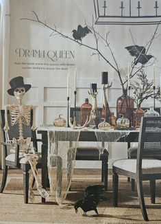 a skeleton sitting at a table in front of a wall with halloween decorations on it