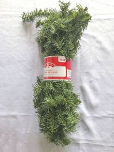 some green plants are laying on a white sheet and one is wrapped in a red tape