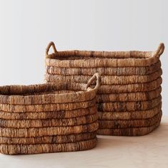 two woven baskets sitting on top of a wooden table