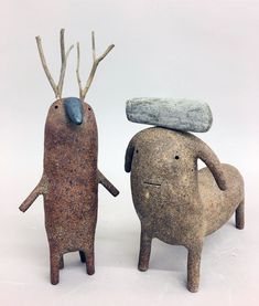 two clay animals with trees on their heads