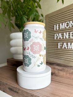 a white vase sitting on top of a wooden shelf next to a sign that says honey pane family