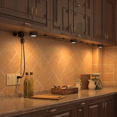 a kitchen with wooden cabinets and tile backsplash, lights above the stovetop