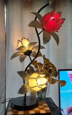 a lamp that is sitting on top of a table next to a laptop computer and flowers