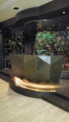 a large sculpture in the middle of a lobby with lights on it's sides