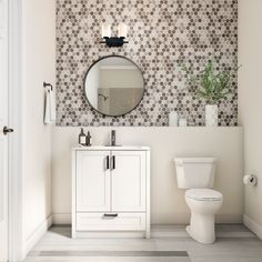 a white toilet sitting next to a bathroom sink under a mirror on top of a wall