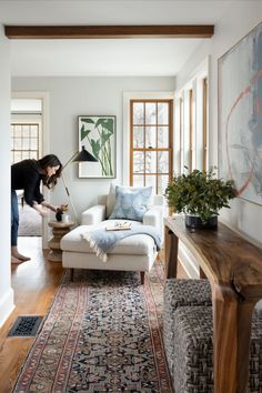 a woman is cleaning the floor in her living room