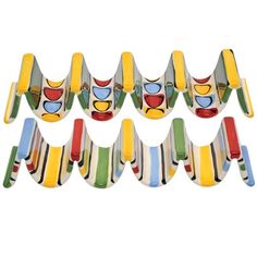 six colorful glasses are lined up in a row on a white background, one is shaped like an airplane and the other has a face