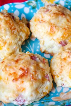 four biscuits with cheese and ham on a blue floraled plate, ready to be eaten