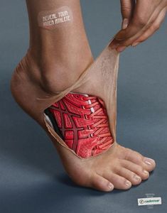 a person's foot with a red shoe cover on it and the bottom part of their feet covered in tape