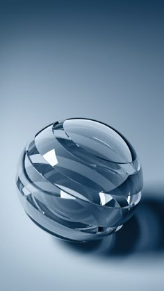 a clear glass bowl sitting on top of a blue tablecloth covered floor with light reflecting off it's surface