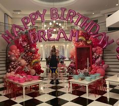 a woman standing in front of a birthday decoration