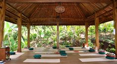 an outdoor yoga room with lots of mats on the floor