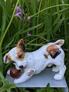 a figurine of a dog with a snail in its mouth