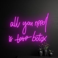 a neon sign that says all you need is love - botox on the wall