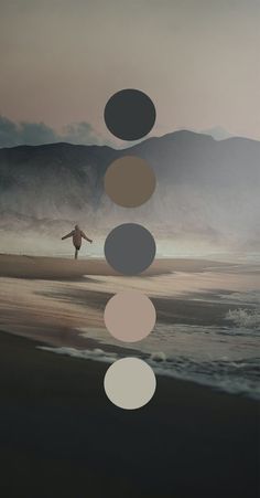 a man standing on top of a beach next to the ocean