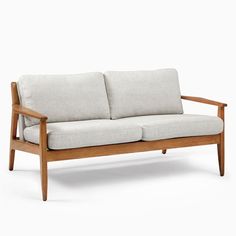 a wooden couch with two pillows on it's back and arm rests against a white background